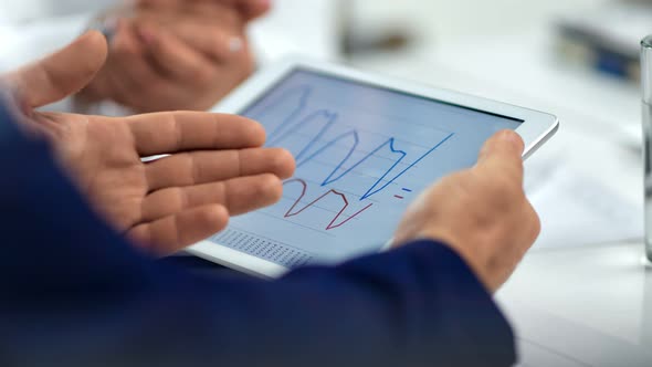 Closeup Businessman Male Hand Holding Tablet Pc Showing Data Graphic Discussing at Team Meeting