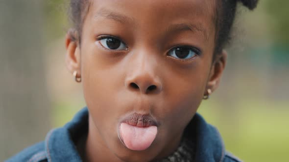 Portrait Child Showing Tongue Closeup Face Cute Little Girl African American Playful Kid Outdoors