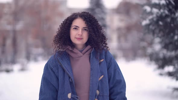 Happy Young Woman with Afro Curls in a Winter City