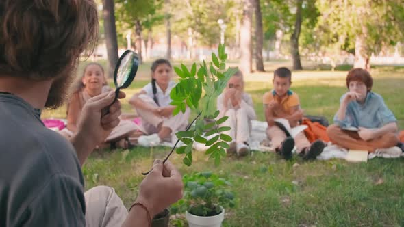 Man Teaching Biology to Curious Children Outdoors