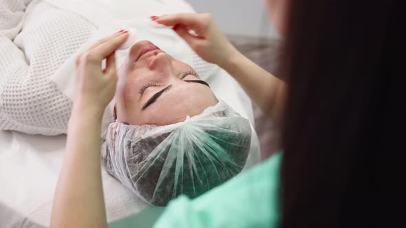 Woman Beautician Makes Facial Skin Care Procedure Female Patient in Beauty Salon