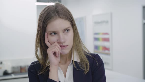 Portrait of Concerned Sad Young Woman in Formal Clothes Looking Away and in the Camera