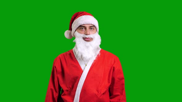 Santa Claus in Red Suit Pointing Aside on Green Chroma Key Background