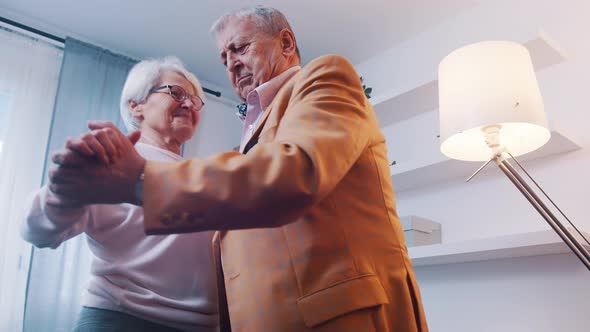 Happy Elderly Retired Couple Dancing at Home