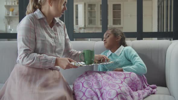 Loving Mother Taking Care of Ill Daughter at Home