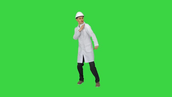 Funny Scientinst in White Robe and Safety Helmet Dancing on a Green Screen, Chroma Key.
