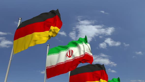 Waving Flags of Iran and Germany on Sky Background