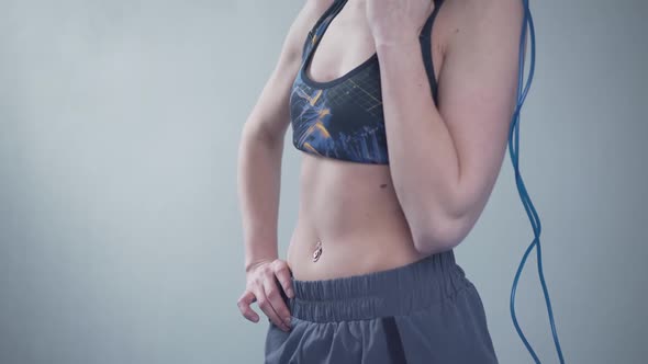 Fit Woman with Jump Rope Posing in the Gym