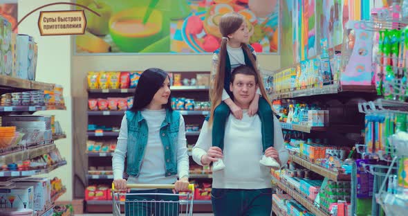 Mom Dad and Daughter are Walking in the Supermarket in the Store