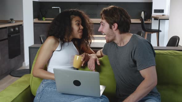 Excited Happy Multiracial Couple Looking at Screen of Laptop Feel Winners Surprised By Lottery