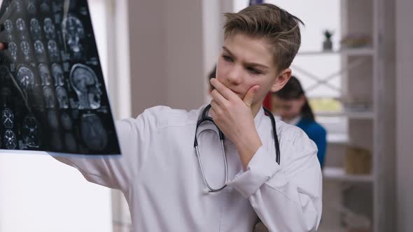 Portrait of Concentrated Little Doctor Examining Brains Xray Thinking