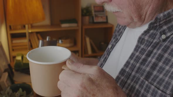 Aged Man Pouring Alcohol in Mug