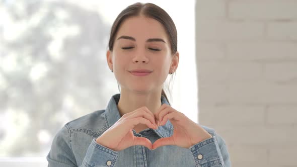 Handmade Heart Gesture By Smiling Young Girl