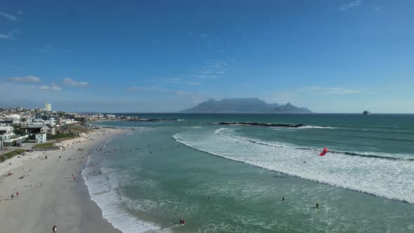 people walking Big Bay Beach and kite surfing in South Africa, aerial