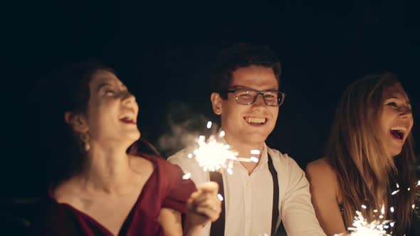 Large Group of Multiracial Friends or Acquaintances Holding and Waving Sparklers