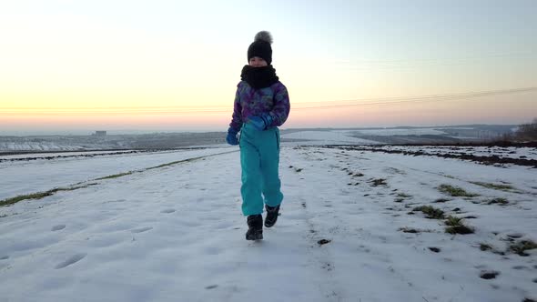 Young child boy having fun outdoors in winter field.