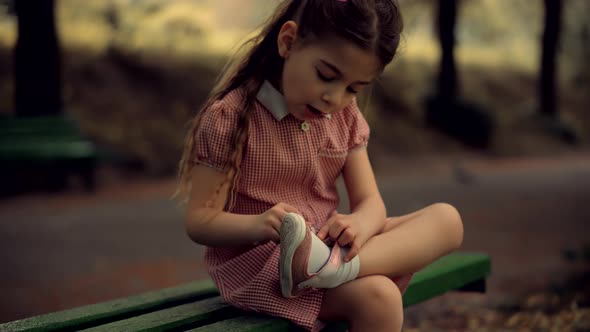 Kid  Sitting And Tying Sneakers Shoes. Preschool Girl Changing Shoes Before Playing With Father.