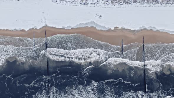 Man on snowy beach in winter at Baltic sea.