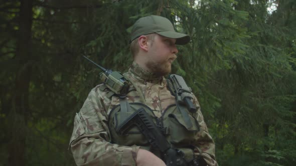 Military Man in Combat Gear Smirking with Selfsatisfaction Outdoors
