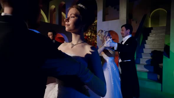 People are Dancing Viennese Waltz in Dark Ballroom in Royal Palace Women in Gorgeous Dresses