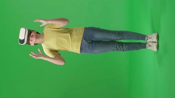 Full Body Of Excited Young Asian Kid Girl Using Virtual Reality Headset In Green Screen Studio