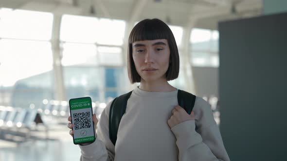 Woman Showing Health Passport on Mobile at Airport