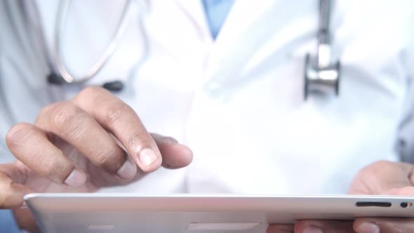 Doctor in White Coat is Using a Digital Tablet