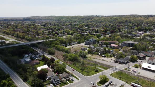 Aerial backwards shot of asphalt highways and bridge with cars in small Canadian village near Lake O