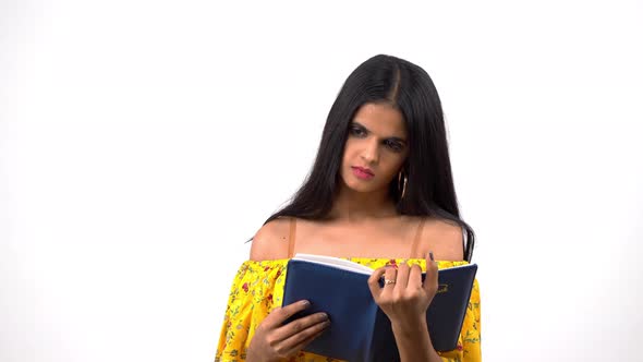 Indian girl reading a diary and thinking about something