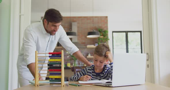 Father helping his son in homework at home 4k