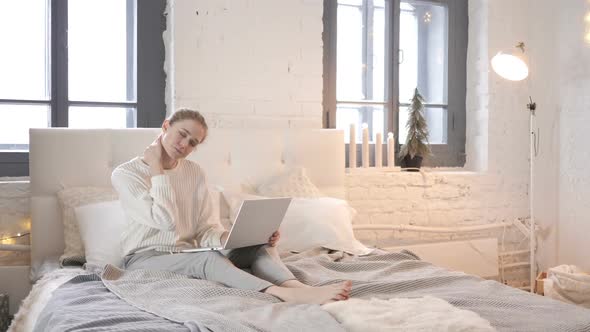 Tired Young Girl with Neck Pain Working on Laptop in Bed