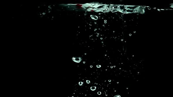 Ultra Slowmo Single Strawberry Splashed into Water on Black Background