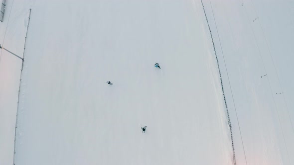 Aerial View Of a group of people skiing down a snowy hill, top-down shot