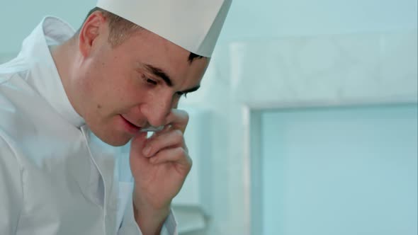 Male Chef in White Uniform Cooking and Talking on the Phone