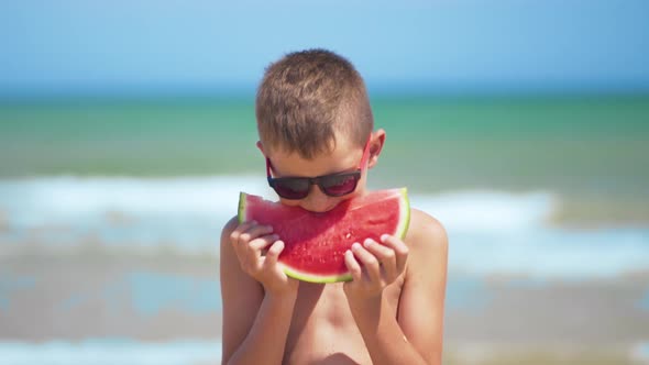 Boy in Black Glasses Eats Watermelon on the Sea