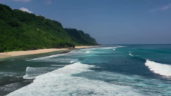 empty white sand beach coastline at Nyang Nyang in Uluwatu Bali with waves crashing, aerial