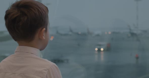 Child Is Attracted with Airport View in the Window