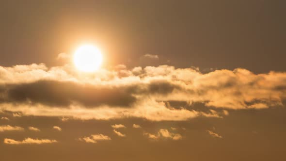 Dramatic Sunset Over the Clouds. Timelapse. Big Yellow Sun Moves Over the Horizon