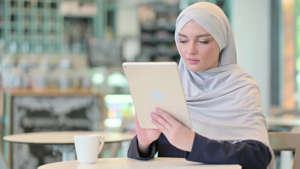 Young Arab Woman Using Tablet in Cafe