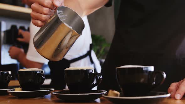 Waiter making coffee at counter