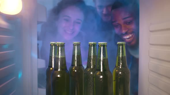 Group of Young Multiethnic Friends Sharing Beer From Fridge for Home Party