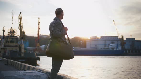Young Stylish Handsome Hipster on Sea Port Background During Sunset