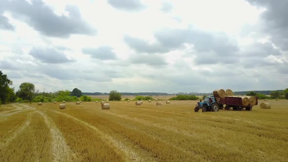 Tractor Loading Bales. Tractor loading bales of straw in the field