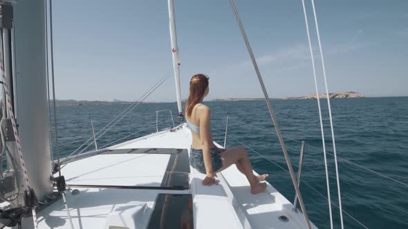 Beautiful Woman on a Yacht Enjoys the Journey on the Background of the Islands of Ibiza or Mallorca