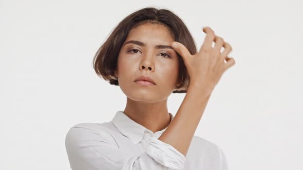 眉毛に触れてカメラを見てチェックシャツの若い美しいブルネット東アジアの女性 / Videohive, Stock footage, Lifestyle