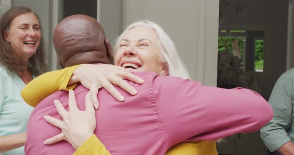 Animation of happy caucasian senior woman embracing african american male friend