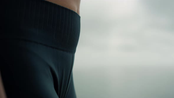 Fit Woman Body Wearing Jeggings on Beach Close Up