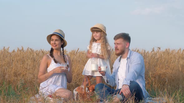 Outdoor Family Picnic, Happy Young Couple with Little Girl Child Looks Far Away During Outings with