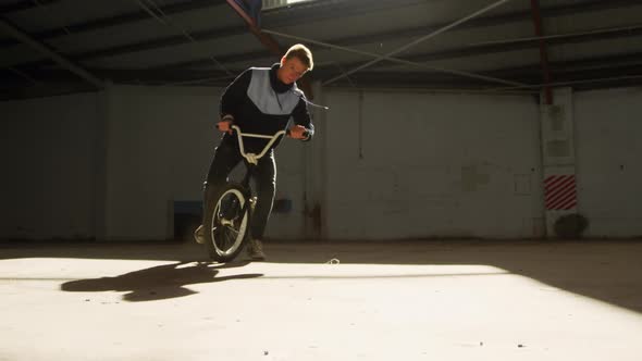 BMX rider in an empty warehouse