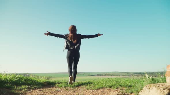 Happy girl running towards the exit with his hands raised up. Freedom. Slow motion.